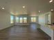 Open-concept living room with wood floors, recessed lighting, and large windows at 737 Raindance St, Erie, CO 80516