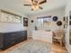 Well-lit bedroom with wood floors and windows, furnished with two dressers and a chair at 6642 S Pearl St, Centennial, CO 80121