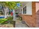 Close-up of a cozy covered front porch with brick accents, manicured plants, and an American flag at 6642 S Pearl St, Centennial, CO 80121