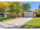 Charming brick home featuring a well-manicured front yard, a long driveway, and an attached two-car garage at 6642 S Pearl St, Centennial, CO 80121