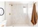 Modern walk-in shower with neutral tiles and brass fixtures at 3624 S Poplar St, Denver, CO 80237