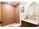 Bathroom featuring earth tone tile, a shower, and a marble countertop with gold hardware at 3624 S Poplar St, Denver, CO 80237