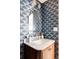 Stylish powder room with unique blue wallpaper and a marble countertop at 3624 S Poplar St, Denver, CO 80237