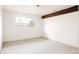 Bedroom with a beam detail, large window, and neutral carpeting at 3624 S Poplar St, Denver, CO 80237