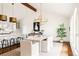 Airy dining room with hardwood floors, modern chandelier, and adjoining kitchen space at 3624 S Poplar St, Denver, CO 80237