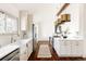 Bright kitchen features white cabinetry, stainless appliances, and a farmhouse sink at 3624 S Poplar St, Denver, CO 80237