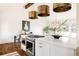 Open kitchen and dining area features stainless steel appliances, a large island, and stylish lighting at 3624 S Poplar St, Denver, CO 80237