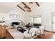 Inviting living room featuring a brick fireplace, exposed wood beams, and lots of natural light at 3624 S Poplar St, Denver, CO 80237