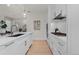 Sleek white kitchen with stainless steel appliances, quartz counters, and hardwood floors at 155 Steele St # 917, Denver, CO 80206