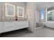 Modern bathroom features a double vanity, backlit mirrors, and a glass-enclosed shower at 155 Steele St # 917, Denver, CO 80206