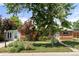 Charming brick home with mature trees, landscaped yard, and covered front porch at 8991 Hickory Pl, Thornton, CO 80229