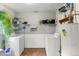 Functional laundry area with side-by-side washer and dryer setup with storage shelves at 8991 Hickory Pl, Thornton, CO 80229
