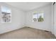 Sunlit bedroom with neutral carpet, white walls, and two large windows showcasing the neighborhood at 24740 E 39Th Ave, Aurora, CO 80019