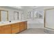Bright bathroom features a dual sink vanity, soaking tub, and a glass enclosed shower at 5149 S Genoa Ct, Centennial, CO 80015
