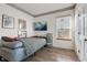Cozy bedroom featuring light-filled window, a flat-screen tv, and wood laminate flooring at 5149 S Genoa Ct, Centennial, CO 80015