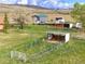 Lovely aerial view of the lot featuring an outbuilding, animal shelter, shed, and mature trees at 6310 W County Road 4, Berthoud, CO 80513