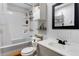 Bathroom features a white vanity, toilet, bathtub with shower, and dark-framed mirror at 6310 W County Road 4, Berthoud, CO 80513