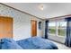 Comfortable bedroom with soft blue accents, a cozy bed, and a large window offering outdoor views at 6310 W County Road 4, Berthoud, CO 80513