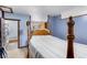 Bedroom features a four-poster bed, carpeting, blue walls, and doorways to the kitchen and bathroom at 6310 W County Road 4, Berthoud, CO 80513
