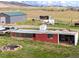 Property exterior with a small red building, white trailer, and storage sheds at 6310 W County Road 4, Berthoud, CO 80513