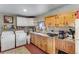 Cozy kitchen featuring white appliances, a washer/dryer hookup, and charming wooden cabinets for storage at 6310 W County Road 4, Berthoud, CO 80513