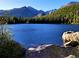 Picturesque lake view surrounded by lush green forest and mountains at 6310 W County Road 4, Berthoud, CO 80513