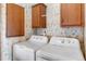 Laundry room showcasing a washer and dryer, complemented by cabinets and floral wallpaper for a classic style at 6310 W County Road 4, Berthoud, CO 80513
