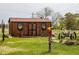 Rustic outbuilding featuring decorative window boxes, flower accents, and adjacent yard decor at 6310 W County Road 4, Berthoud, CO 80513