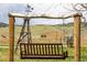 Inviting wooden yard swing hanging beneath a charming frame with scenic hillside views at 6310 W County Road 4, Berthoud, CO 80513