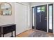 Bright foyer with a dark door, white closet, and hardwood flooring with a decorative rug at 7379 S Lafayette W Cir, Centennial, CO 80122