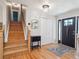 Open foyer features hardwood floors, a staircase, closet, and a stylish black entry door at 7379 S Lafayette W Cir, Centennial, CO 80122
