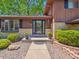 Front entrance with stone pathway, manicured landscaping, brick accents, and a glass front door at 7379 S Lafayette W Cir, Centennial, CO 80122