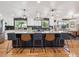 Large kitchen island with stone countertop, seating for five, modern lighting, and a stainless steel hood at 7379 S Lafayette W Cir, Centennial, CO 80122