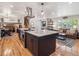 Open kitchen with large island, stainless steel appliances, and hardwood floors flowing into living room at 7379 S Lafayette W Cir, Centennial, CO 80122
