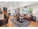 Spacious living room featuring hardwood floors, leather sofa, large windows, and modern decor at 7379 S Lafayette W Cir, Centennial, CO 80122