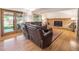 Spacious living room featuring a brick fireplace, hardwood floors, and access to the outdoor patio at 7379 S Lafayette W Cir, Centennial, CO 80122