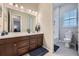 Well-lit bathroom showcasing a single sink vanity, mirror, and tiled floors at 3630 Gold Bug St, Aurora, CO 80019