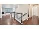 Bright hallway with hardwood floors, white railings, and an open view into a living area with a fireplace at 3630 Gold Bug St, Aurora, CO 80019