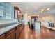 Bright, open kitchen featuring dark cabinetry, granite counters, a central island, and hardwood flooring at 3630 Gold Bug St, Aurora, CO 80019
