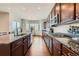 Open-concept kitchen with granite countertops, stainless steel appliances, and stylish wood cabinets at 3630 Gold Bug St, Aurora, CO 80019