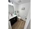 Updated half bathroom featuring a vanity with black cabinets, gold pulls, and wood look floors at 3575 S Ouray St, Aurora, CO 80013