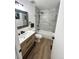 Modern bathroom with a wood vanity, matte black fixtures, and a white shower and tub combo at 3575 S Ouray St, Aurora, CO 80013