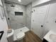 Modern bathroom featuring a gray tiled shower with a built-in niche and black fixtures at 3575 S Ouray St, Aurora, CO 80013