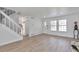 Bright living room featuring wood-look flooring, staircase, white trim, and lots of natural light at 3575 S Ouray St, Aurora, CO 80013