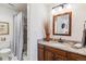 Bright bathroom featuring granite counters, a wood vanity and a shower with tile surround at 2437 E Geddes Pl, Centennial, CO 80122