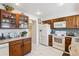 Bright kitchen features ample wood cabinetry, white appliances, and tiled flooring at 2437 E Geddes Pl, Centennial, CO 80122