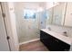 Modern bathroom featuring double sink vanity, quartz counters, and glass shower at 5462 S Cedar St, Littleton, CO 80120