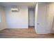 Bedroom featuring hardwood-style floors, a modern AC unit, and an interior door at 5462 S Cedar St, Littleton, CO 80120