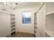 Bright walk-in closet with custom shelves, hanging rods, and a window with a view of the outdoors at 5462 S Cedar St, Littleton, CO 80120