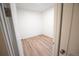 A small walk-in closet features hardwood-style flooring, white walls, and a single lighting fixture at 5462 S Cedar St, Littleton, CO 80120
